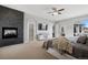 Carpeted bedroom with a fireplace, tv, ceiling fan, and a cozy aesthetic at 5310 Craftsman Dr, Parker, CO 80134