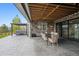 Covered patio with a hot tub area and an outdoor dining table for entertaining at 5310 Craftsman Dr, Parker, CO 80134