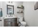 Cozy half bathroom featuring modern vanity, a decorative mirror, and neutral paint at 5310 Craftsman Dr, Parker, CO 80134