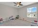 Bright bedroom featuring a ceiling fan and a large window overlooking neighborhood views at 5166 Trails Edge Ln, Castle Rock, CO 80104