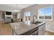 Kitchen island with stainless steel sink, granite countertops, and view to the dining and living rooms at 5166 Trails Edge Ln, Castle Rock, CO 80104