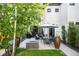 A backyard with patio, outdoor dining area, fire pit, and mature landscaping surrounded by white stucco walls at 3617 Shoshone St, Denver, CO 80211
