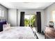 Bedroom with black framed balcony doors looking out to trees and a balcony with a chair at 3617 Shoshone St, Denver, CO 80211