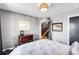 Bedroom with gray walls, wooden dresser, and a doorway with an open view of wooden stairs at 3617 Shoshone St, Denver, CO 80211
