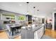 Modern kitchen with a large island, stainless steel sink, and an open layout to the dining and living areas at 3617 Shoshone St, Denver, CO 80211