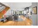 Bright open-concept living room featuring hardwood floors, a fireplace, and an open staircase at 3617 Shoshone St, Denver, CO 80211