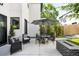 A white stucco house showing a patio space with outdoor furniture, a fire pit, and decorative foliage at 3617 Shoshone St, Denver, CO 80211