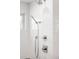 Modern white-tiled shower with sleek fixtures includes a rainfall showerhead and a handheld sprayer, offering a spa-like experience at 3617 Shoshone St, Denver, CO 80211