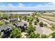 Wide aerial view of a home with solar panels near a lake, park, and walking trails under a blue sky at 9530 E 113Th Ave, Commerce City, CO 80640