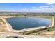 Expansive aerial view of community lake bordered by lush green space and roadways at 9530 E 113Th Ave, Commerce City, CO 80640