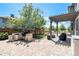 A backyard patio features a built-in grill, a pergola over outdoor seating, and a grassy yard beyond a wooden fence at 9530 E 113Th Ave, Commerce City, CO 80640