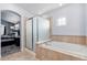 Bright bathroom featuring a glass enclosed shower, large soaking tub, and a window at 9530 E 113Th Ave, Commerce City, CO 80640