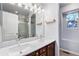 Bathroom with dual sinks, framed mirror, and a glass enclosed shower visible in the reflection at 9530 E 113Th Ave, Commerce City, CO 80640