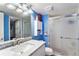 Updated bathroom with bright blue walls, a marble countertop, and glass enclosed shower at 9530 E 113Th Ave, Commerce City, CO 80640
