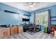 Bright bedroom with light blue walls, gray carpet, two floating shelves, and a desk by the window at 9530 E 113Th Ave, Commerce City, CO 80640