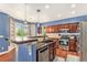 Bright kitchen features a breakfast bar, stainless steel appliances, and wood cabinetry at 9530 E 113Th Ave, Commerce City, CO 80640