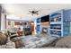Open-concept living room with a fireplace, built-in shelving, and an adjacent kitchen and dining area at 9530 E 113Th Ave, Commerce City, CO 80640