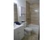 Bathroom with a toilet, shower with tan tile, white vanity and cabinet storage at 10966 Josephine St, Northglenn, CO 80233
