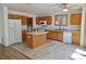 Bright kitchen features an island, wood cabinets, white appliances, and modern flooring at 10966 Josephine St, Northglenn, CO 80233