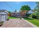 Spacious backyard featuring a brick patio, a lush lawn, and outdoor storage at 755 S Clay St, Denver, CO 80219