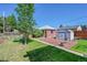 Private backyard with a brick patio, green lawn, and storage shed at 755 S Clay St, Denver, CO 80219