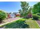 Expansive backyard showcasing a brick patio, lush lawn, and storage solutions at 755 S Clay St, Denver, CO 80219