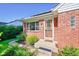 Inviting front entrance with a charming brick facade, well-kept landscaping, and a decorative storm door at 755 S Clay St, Denver, CO 80219