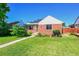 Charming brick home with a well-maintained lawn, tidy landscaping, and solar panels on a sunny day at 755 S Clay St, Denver, CO 80219