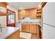 Bright kitchen features wooden cabinets, tile floors, stone countertops, and red exterior door at 755 S Clay St, Denver, CO 80219