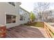 Large deck with wooden railings adjoins a manicured lawn and side of house with ample windows at 9525 W Victoria Dr, Littleton, CO 80128