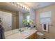 Bathroom with a large mirror, light fixtures, a sink, and a toilet at 9525 W Victoria Dr, Littleton, CO 80128