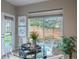 Sunlit dining area with a glass table and views of the backyard through a large window at 9525 W Victoria Dr, Littleton, CO 80128