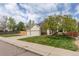 Charming home with a well-manicured lawn, mature tree, and a two-car garage at 9525 W Victoria Dr, Littleton, CO 80128