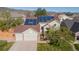 Inviting front of home with a three-car garage, solar panels, and mountain views at 9525 W Victoria Dr, Littleton, CO 80128