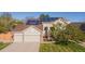 Inviting front of home with a three-car garage, solar panels, and well-maintained lawn at 9525 W Victoria Dr, Littleton, CO 80128