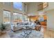 Spacious living room with high ceilings, large windows, and seamless flow to kitchen at 9525 W Victoria Dr, Littleton, CO 80128