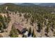Captivating aerial view of a residence surrounded by dense trees, showcasing a spacious garage and charming exterior at 12672 Rancho Ct, Conifer, CO 80433