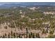 Expansive aerial view of a wooded property with a house nestled amidst towering pines, showcasing its secluded location at 12672 Rancho Ct, Conifer, CO 80433