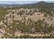 Extensive aerial perspective showcasing homes on a hill surrounded by trees, offering a serene and private residential setting at 12672 Rancho Ct, Conifer, CO 80433