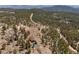 Scenic aerial view reveals a secluded home enveloped by lush forest, highlighting its tranquility and natural setting at 12672 Rancho Ct, Conifer, CO 80433