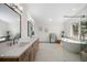 Elegant bathroom featuring double sinks, ample counter space, and a soaking tub near a large window at 12672 Rancho Ct, Conifer, CO 80433