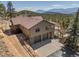 Mountain home featuring a three car garage, a paved walkway, and a stairway to the deck at 12672 Rancho Ct, Conifer, CO 80433