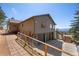 Tan home with a two-car garage, stone pathway and a wooden fence at 12672 Rancho Ct, Conifer, CO 80433