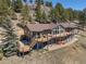 Expansive wooden deck with seating offers stunning mountain views from this charming hillside home at 12672 Rancho Ct, Conifer, CO 80433