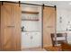 Wet bar with wooden sliding doors, white subway tile backsplash, and wooden shelves at 12672 Rancho Ct, Conifer, CO 80433