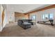 Spacious living room with a comfortable sectional sofa, wood accent wall, and access to outdoor views at 12672 Rancho Ct, Conifer, CO 80433