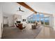 Bright living room showcasing a stone fireplace, vaulted ceilings, beam, and a wall of windows with mountain views at 12672 Rancho Ct, Conifer, CO 80433
