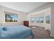 Bright main bedroom featuring carpet floors, large windows with scenic mountain views, and comfortable sleeping arrangements at 12672 Rancho Ct, Conifer, CO 80433
