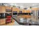 Kitchen featuring granite counters, stainless steel appliances, and wooden cabinetry, ideal for cooking and entertaining at 11367 S Blackthorn Ct, Parker, CO 80134