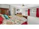 Bright main bedroom with an ensuite bath, red curtains, and a door to the exterior at 11367 S Blackthorn Ct, Parker, CO 80134